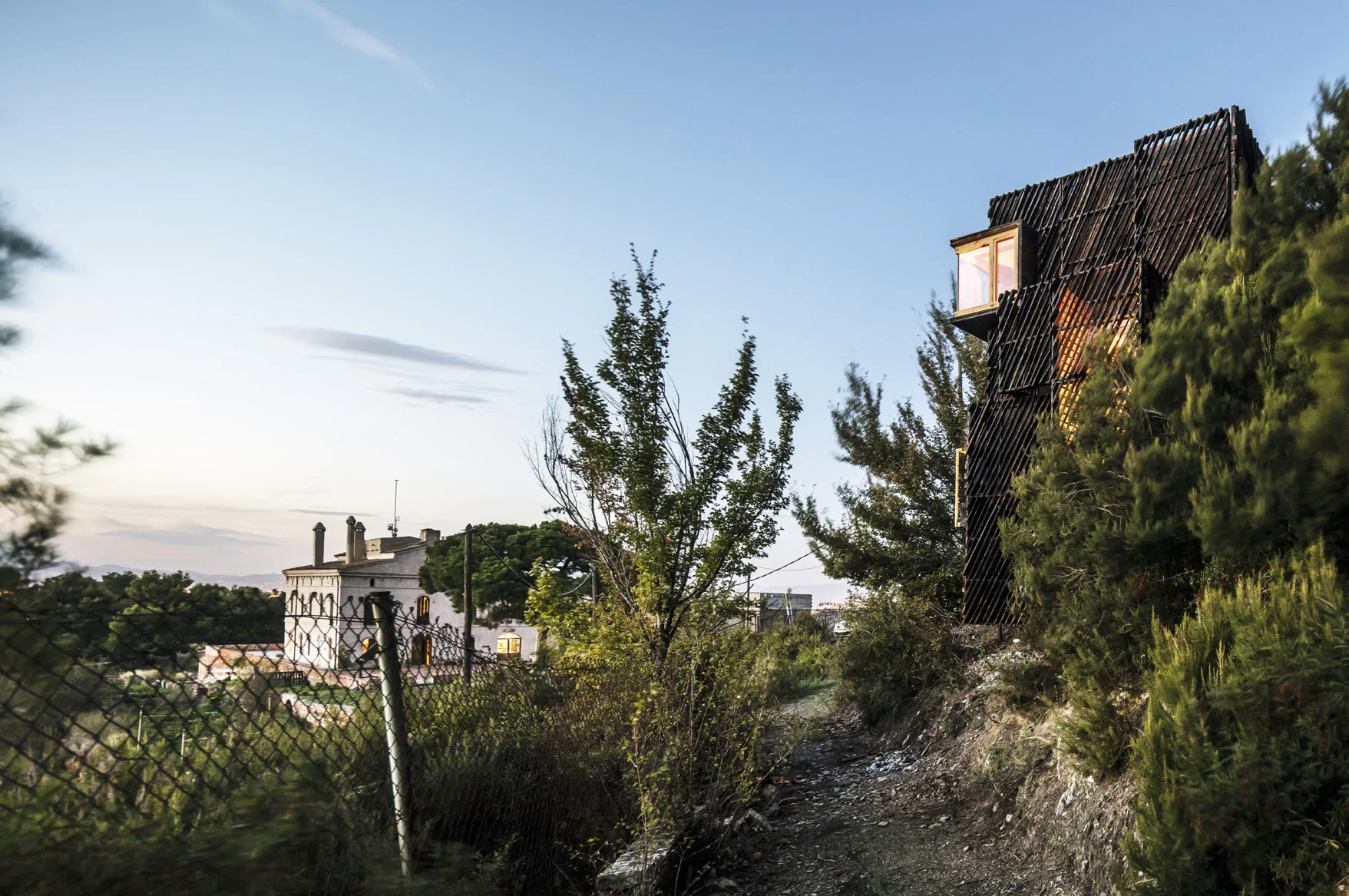 The Voxel, a small cross-laminated timber cabin on a wooded hillside among pine trees near Barcelona