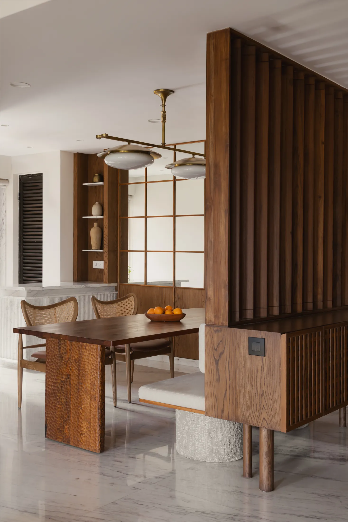 home in•between teak louvre partition beside the dining table and stone bench