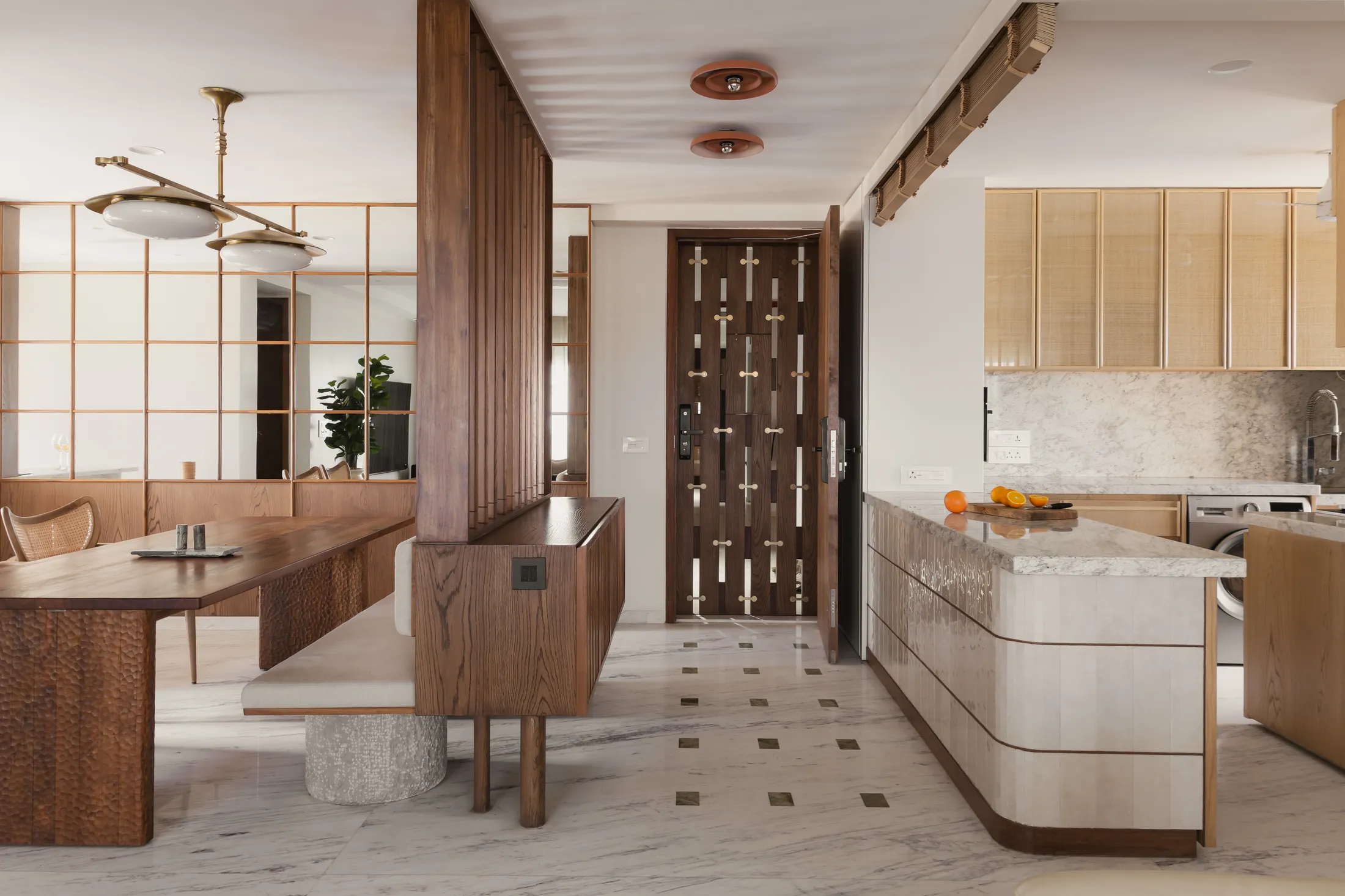 home in•between view from the dining area to a curved kitchen island over a patterned marble floor