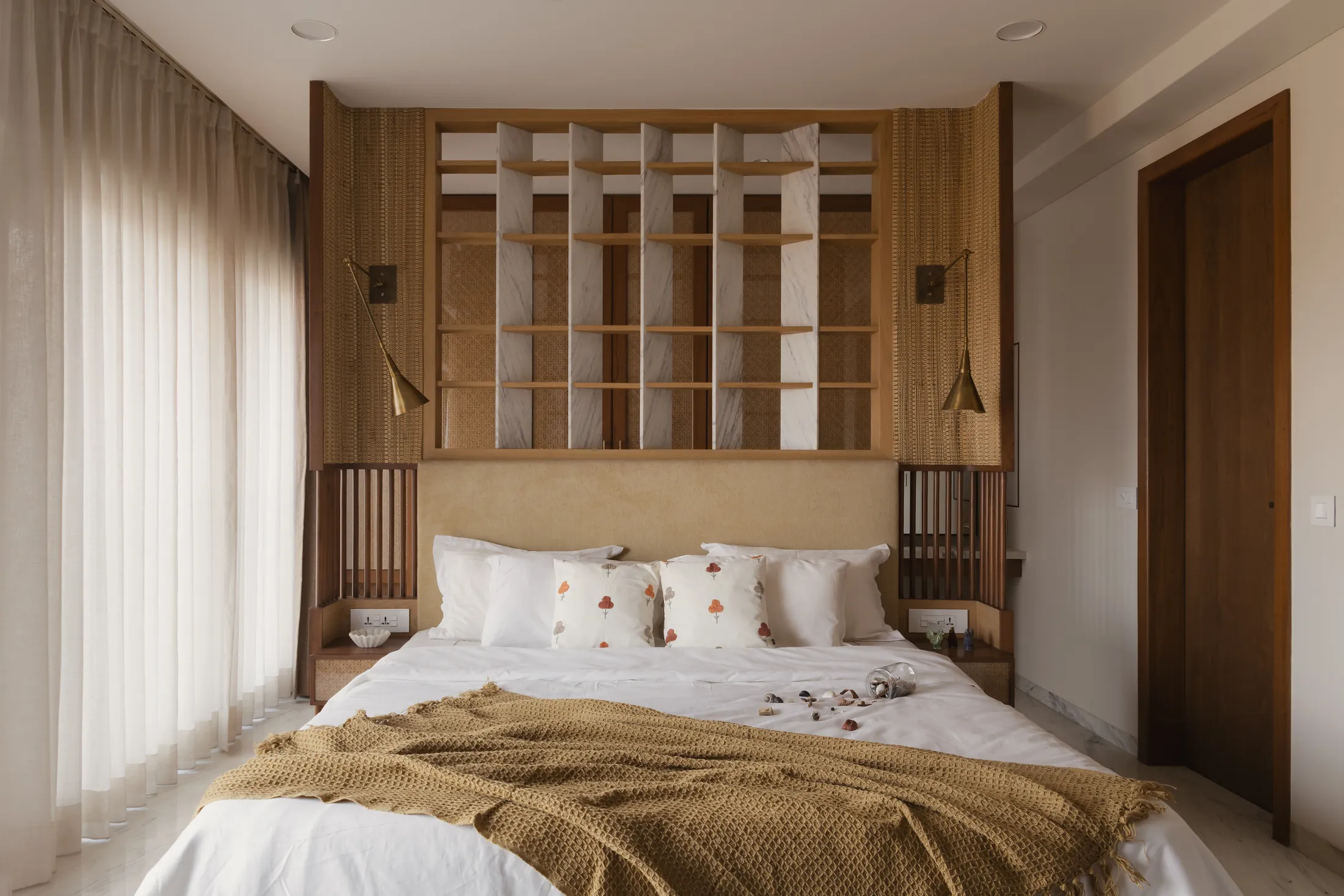home in•between primary bedroom with an upholstered bed against a timber grid headboard wall