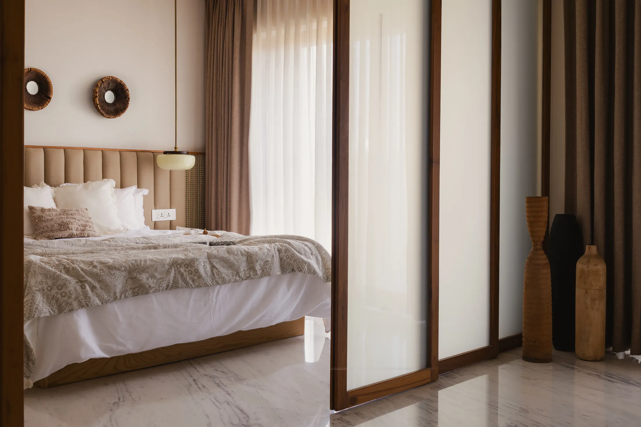 home in•between second bedroom with a padded headboard and a glass partition towards the balcony