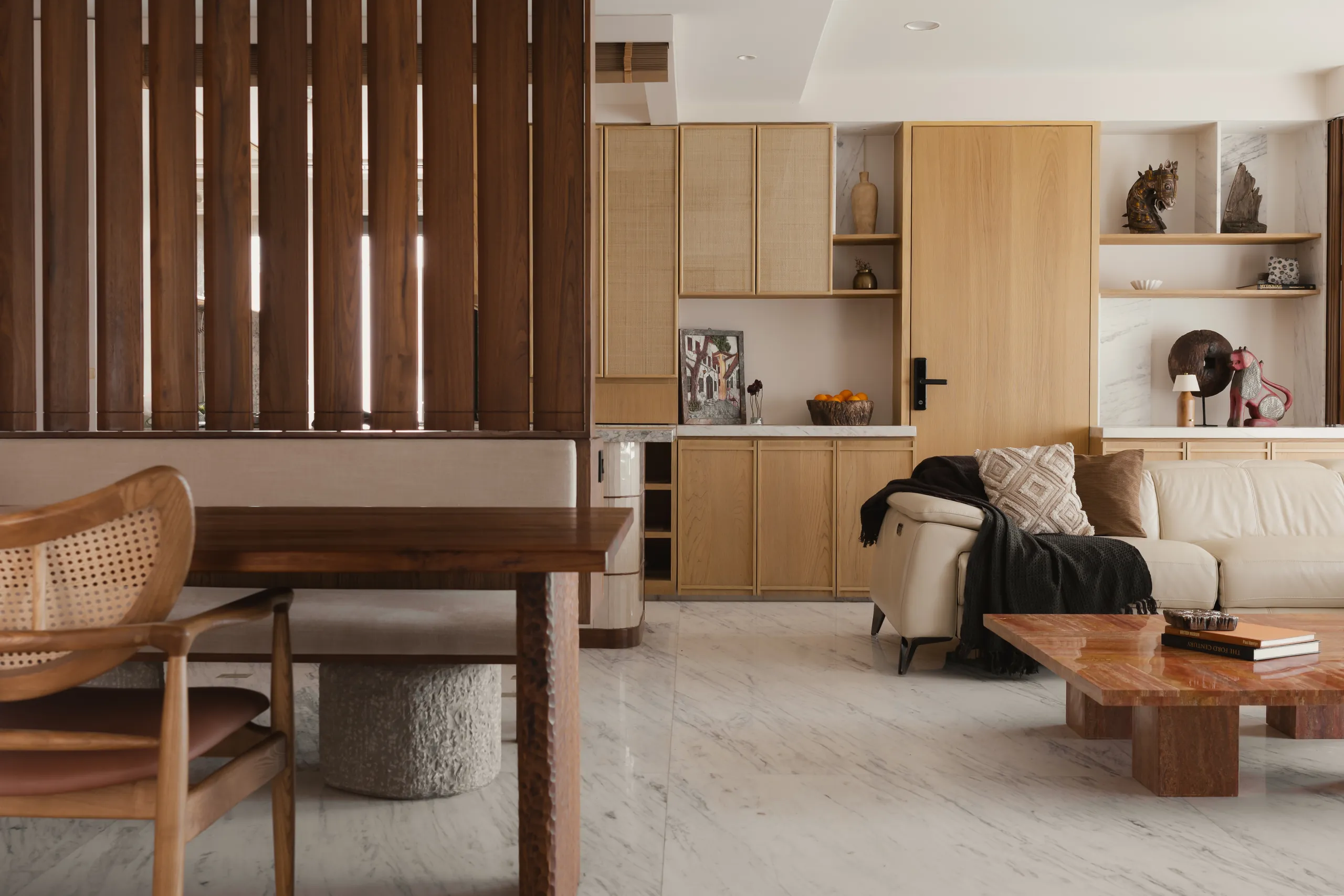 home in•between living and dining room with a teak slat partition, cane chairs and lounge chair