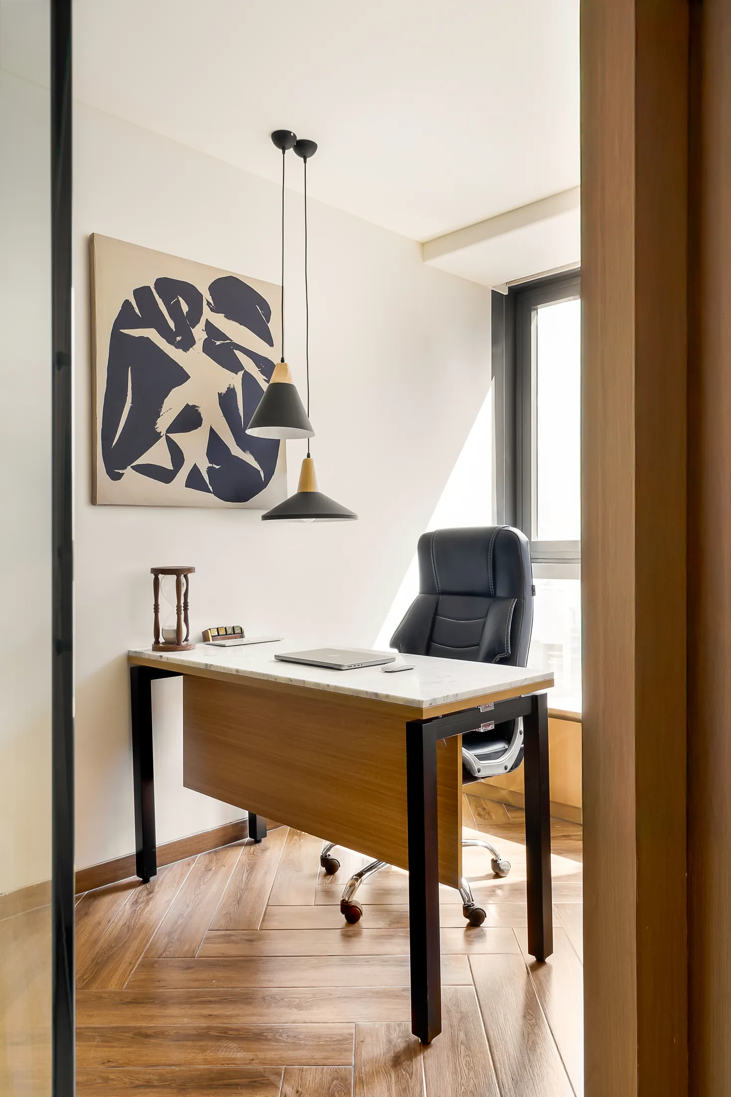 Into the Bend private cabin with a desk, black chair, pendant lights and abstract artwork