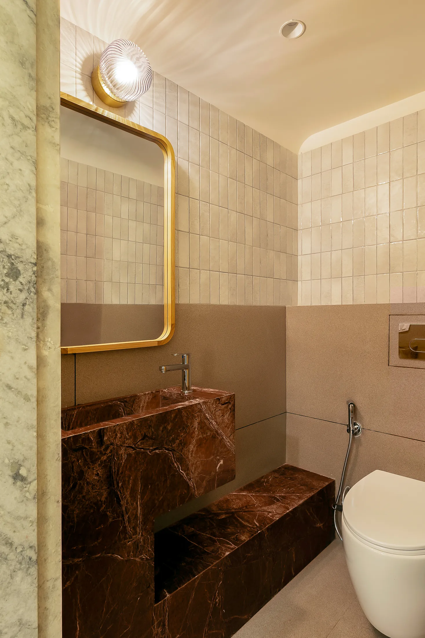 Into the Bend office washroom with a brown-red marble basin, brass fittings and lime-green tiles