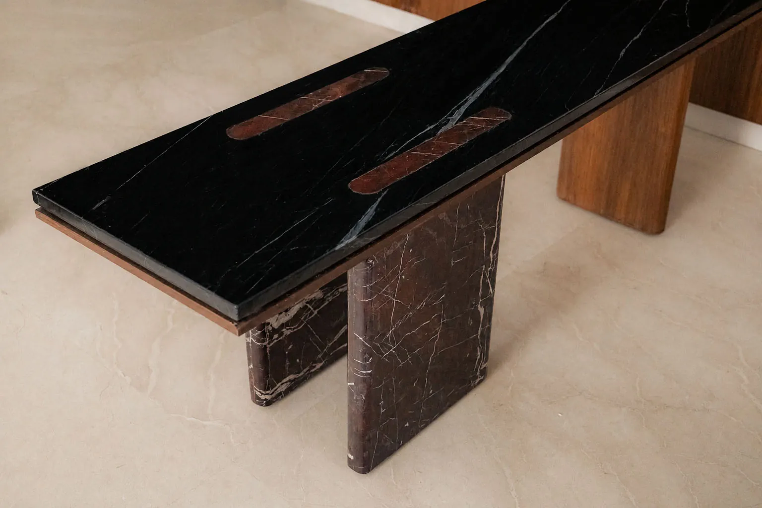 Custom black marble table with red marble inlays on timber and red marble legs in Plum House