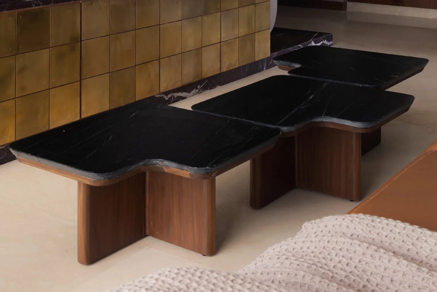 Plum House sculptural black marble coffee tables on cross-shaped timber bases