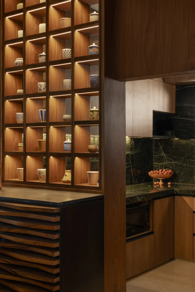 Lit timber cubbies inspired by Kyoto teahouses separating the kitchen from the living room in Plum House