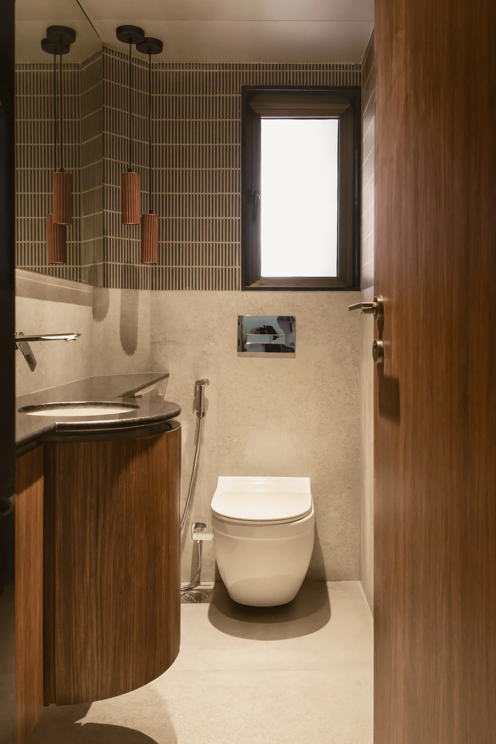 The Nest powder room with a curved timber vanity, terracotta pendant lights, green tiles and a wall-hung WC