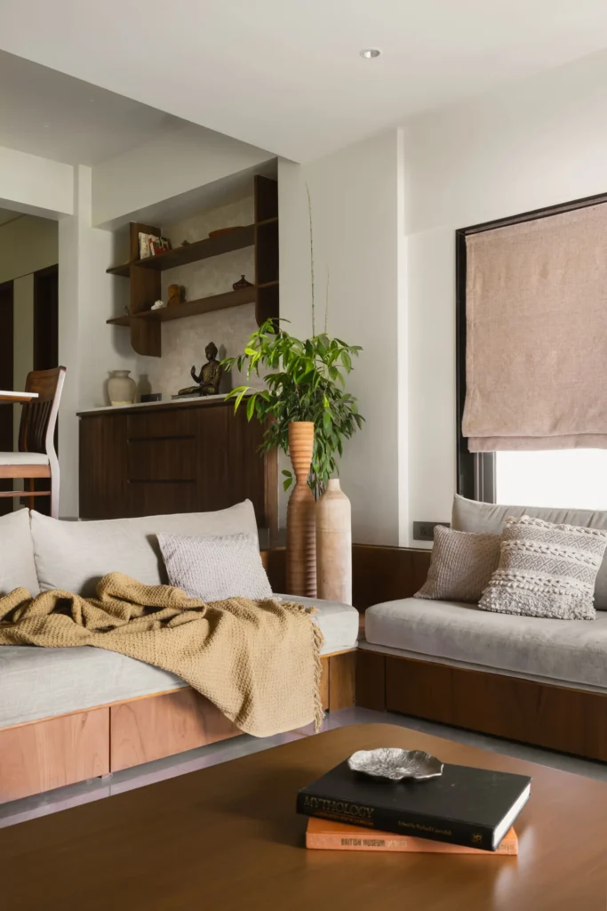 Living room of The Nest in Juhu with a built-in daybed, timber shelving and a Roman blind
